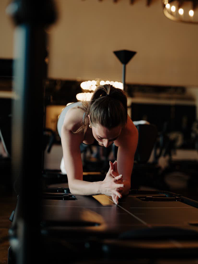 Coach working across a Megaformer under the chandeliers