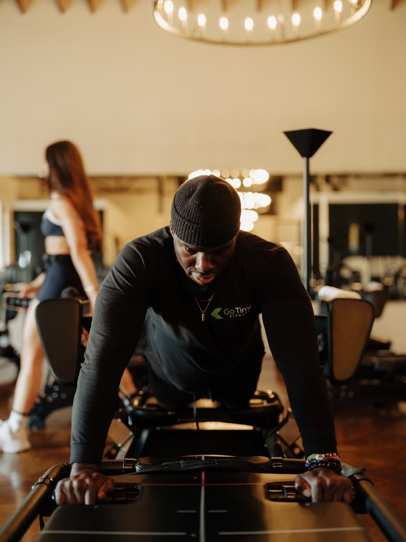 Coach pressing through a plank on the Megaformer